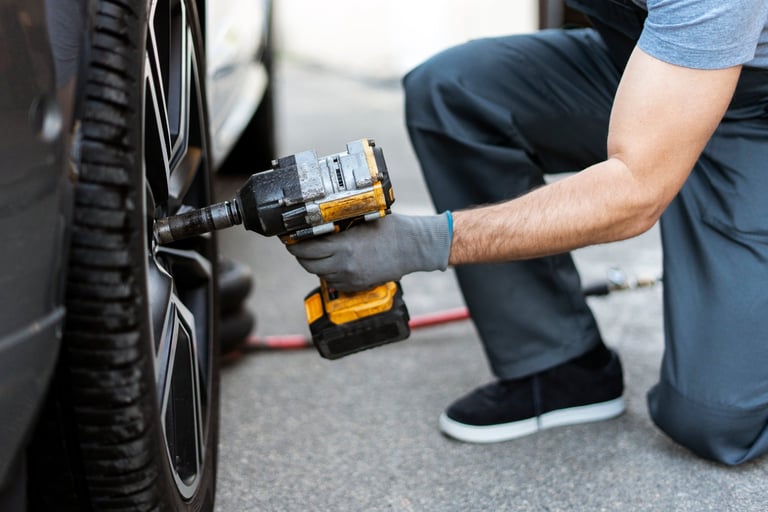 Mechanic changing tire with impact wrench